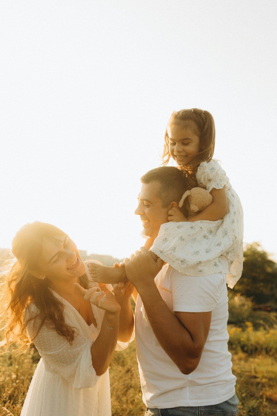 Eine lachende Familie spaziert durch ein Feld.
